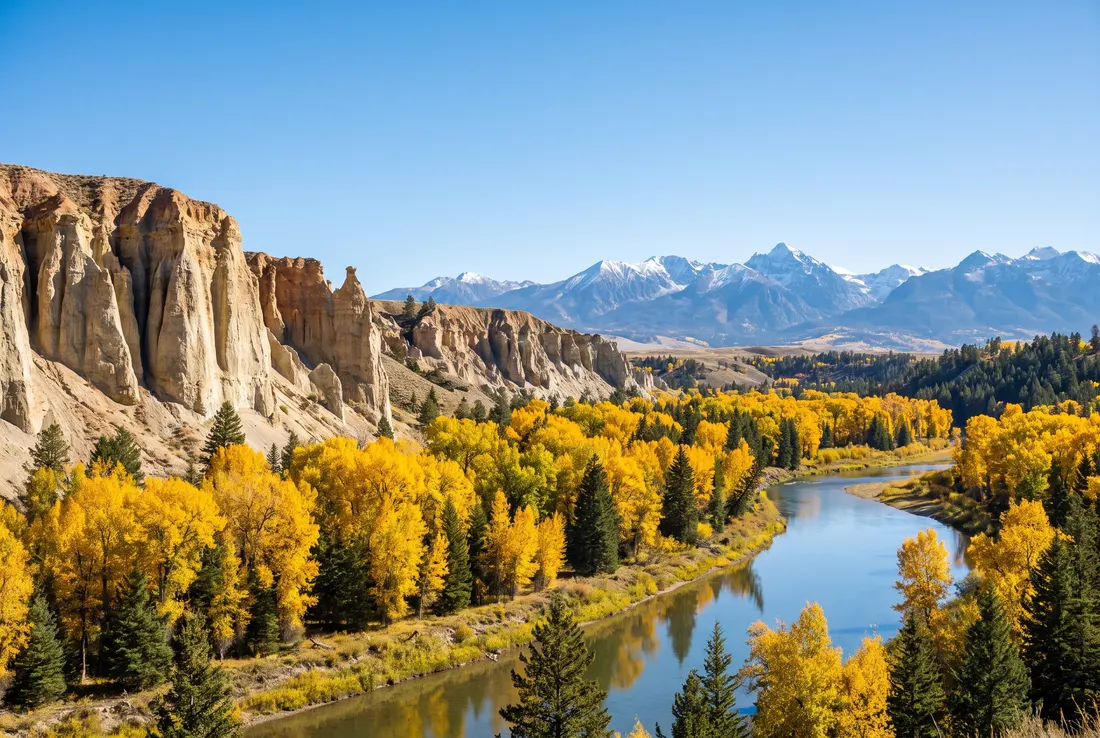 Pale hoodoo cliffs above a river valley in autumn